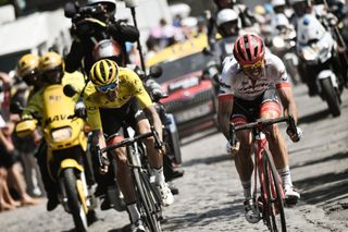 John Degenkolb and Greg Van Avermaet wearing the overall leader's yellow jersey ride through a cobblestone section during stage 9 of the 105th edition of the Tour de France