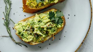 Slices of toast with smashed avocado and rosemary