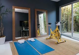gym area with yoga mat and blue wall and glass door