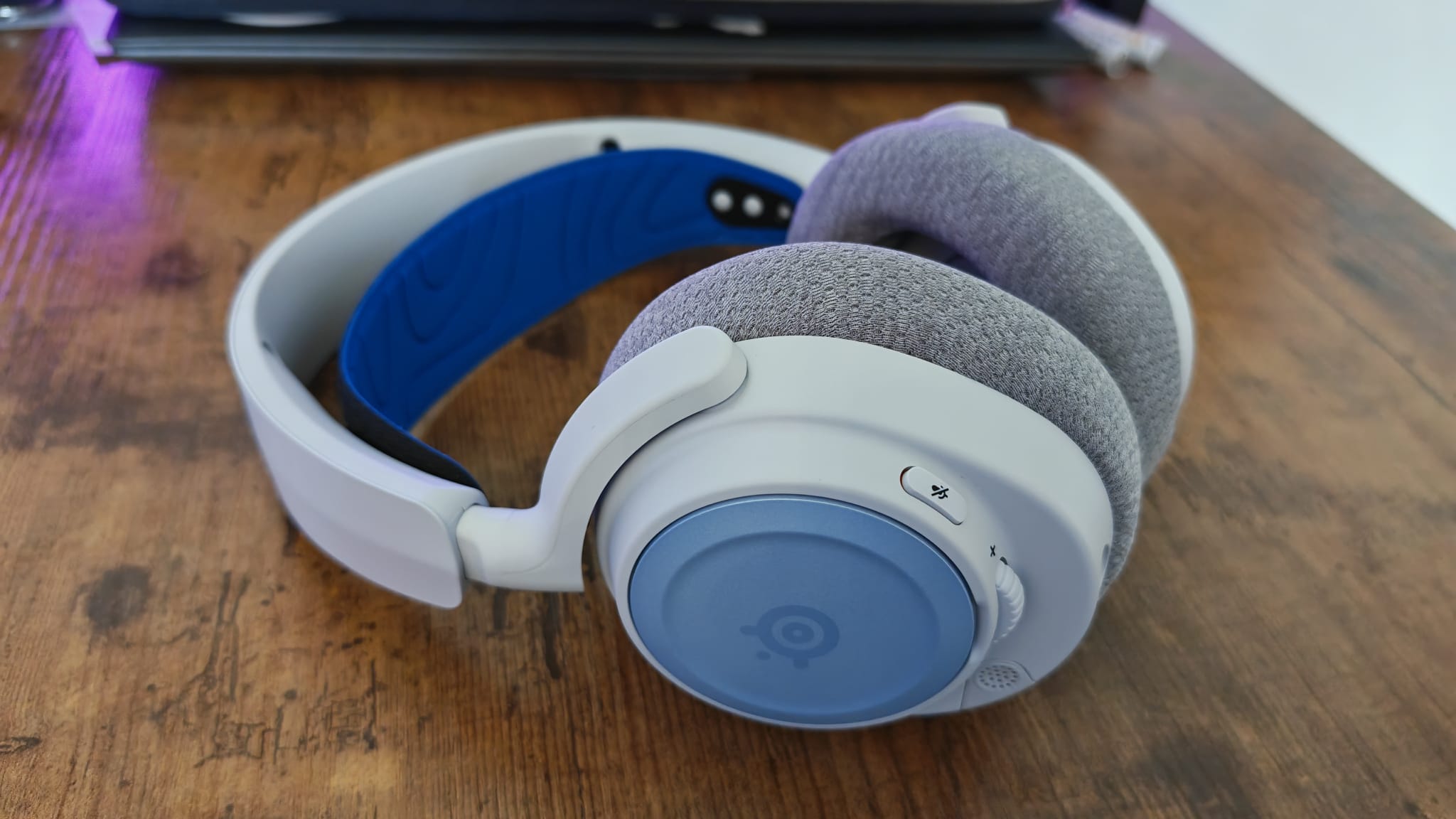 Blue accessories and grey ear cushions on the SteelSeries Arctis Nova 7P
