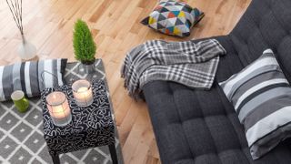 A bright living room with items on the sofa and coffee table