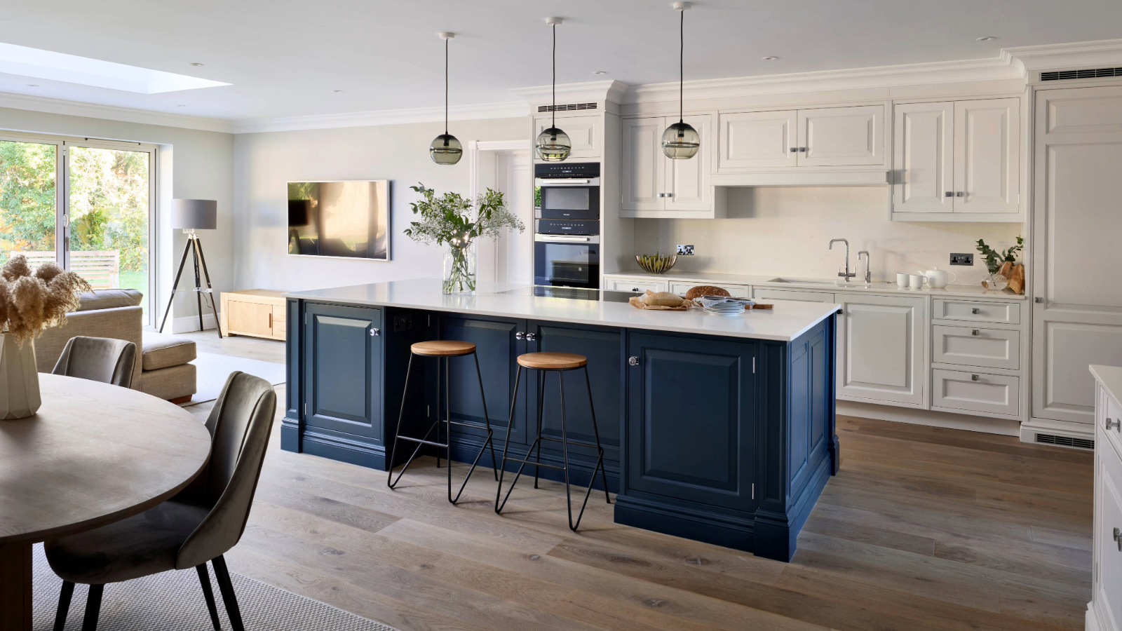 Open plan kitchen with blue island and white cabinets