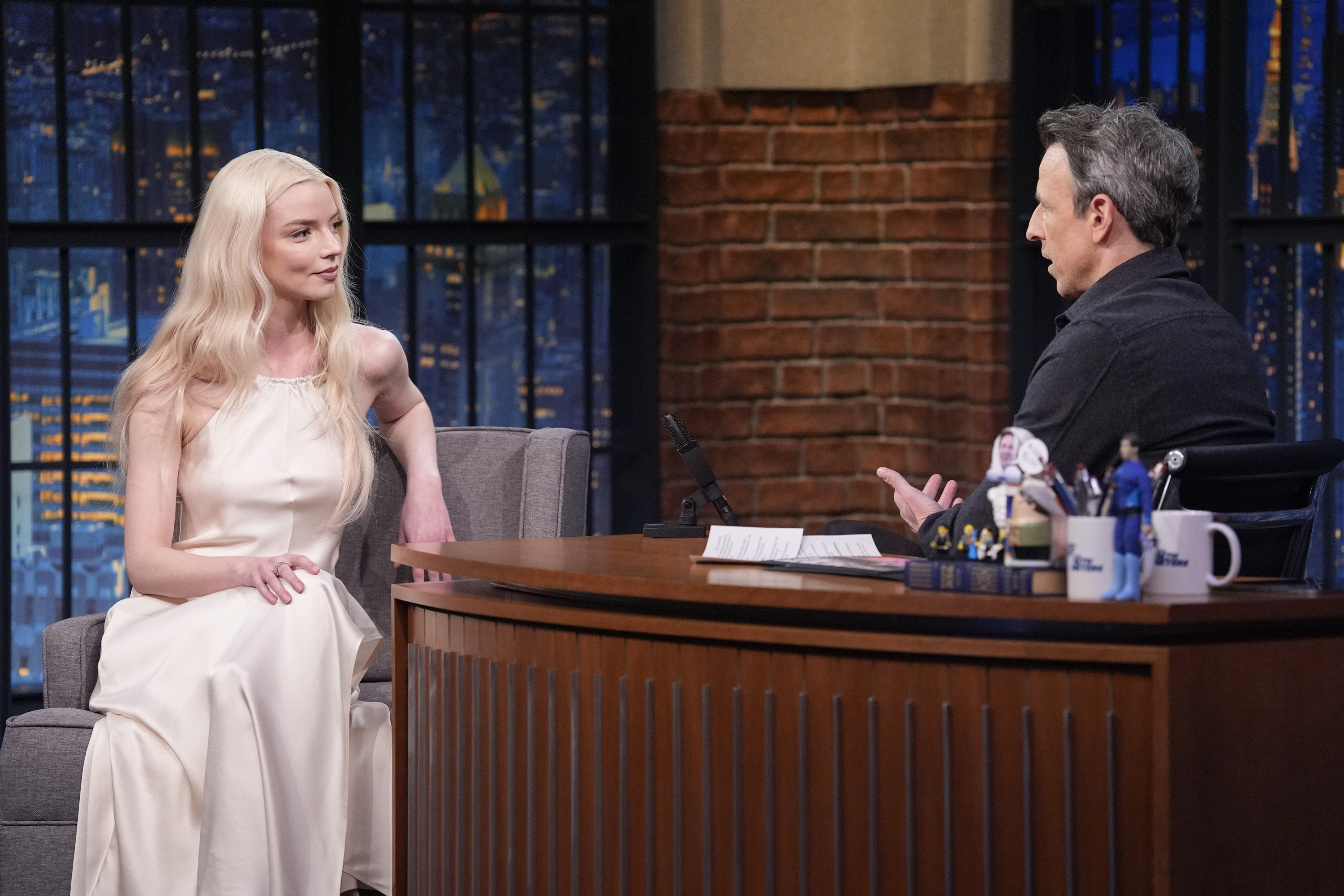 a photo of a man and a woman sitting across from each other on a talk show set