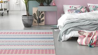 Bedroom with walls painted in pastel shades a colourful patterned rug on the floor