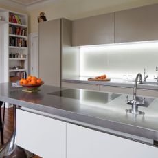 Kitchen with indoor strip lighting under cabinets and stainless steel countertop