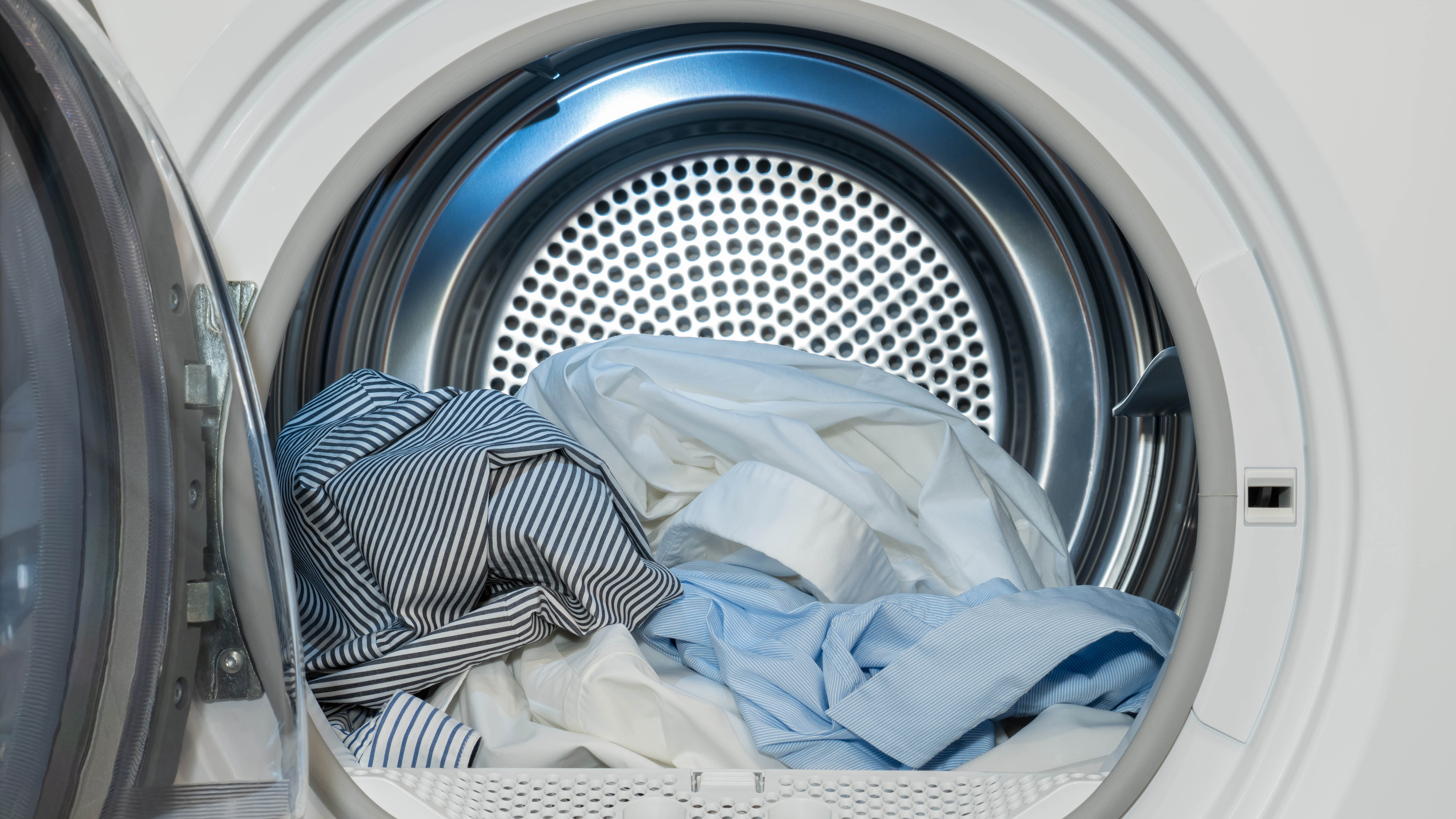 A close up of a clothes dryer's drum with dry clothes