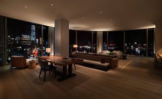 Interior view of an apartment with glass walls and laminate flooring. and a view of the city. Photographed with dimmed lights.