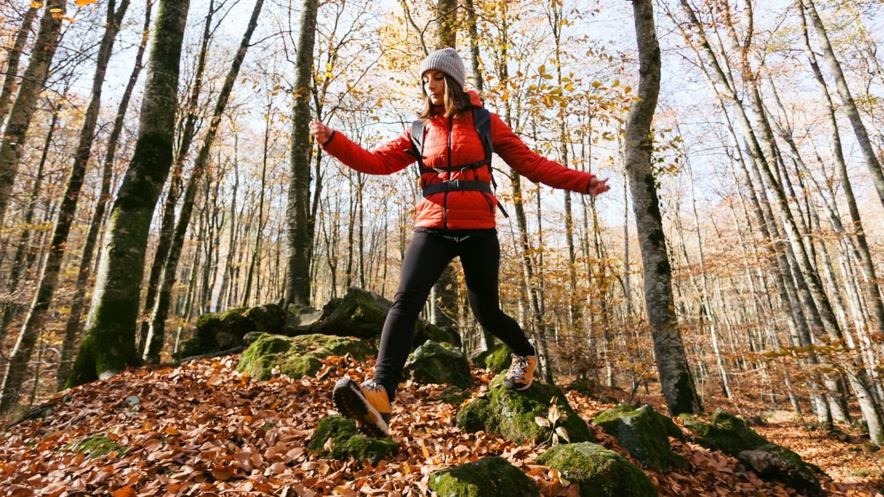 Woman speed hiking through the woods