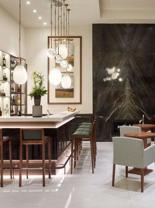 A beautifully lit hotel bar features egg-shaped pendant lights imbuing the space with an intimate atmosphere.