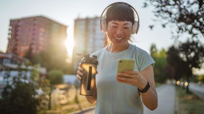 Woman drinking best electrolyte powders during heatwave in evening sunshine