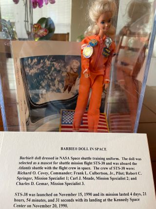 The first Barbie doll to fly in space as displayed in Steve Denison's home, together with the descriptive card from its 1999 exhibit at the Eisenhower Presidential Library in Kansas.