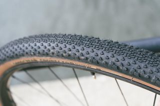 A tan gravel tyre against a black raining