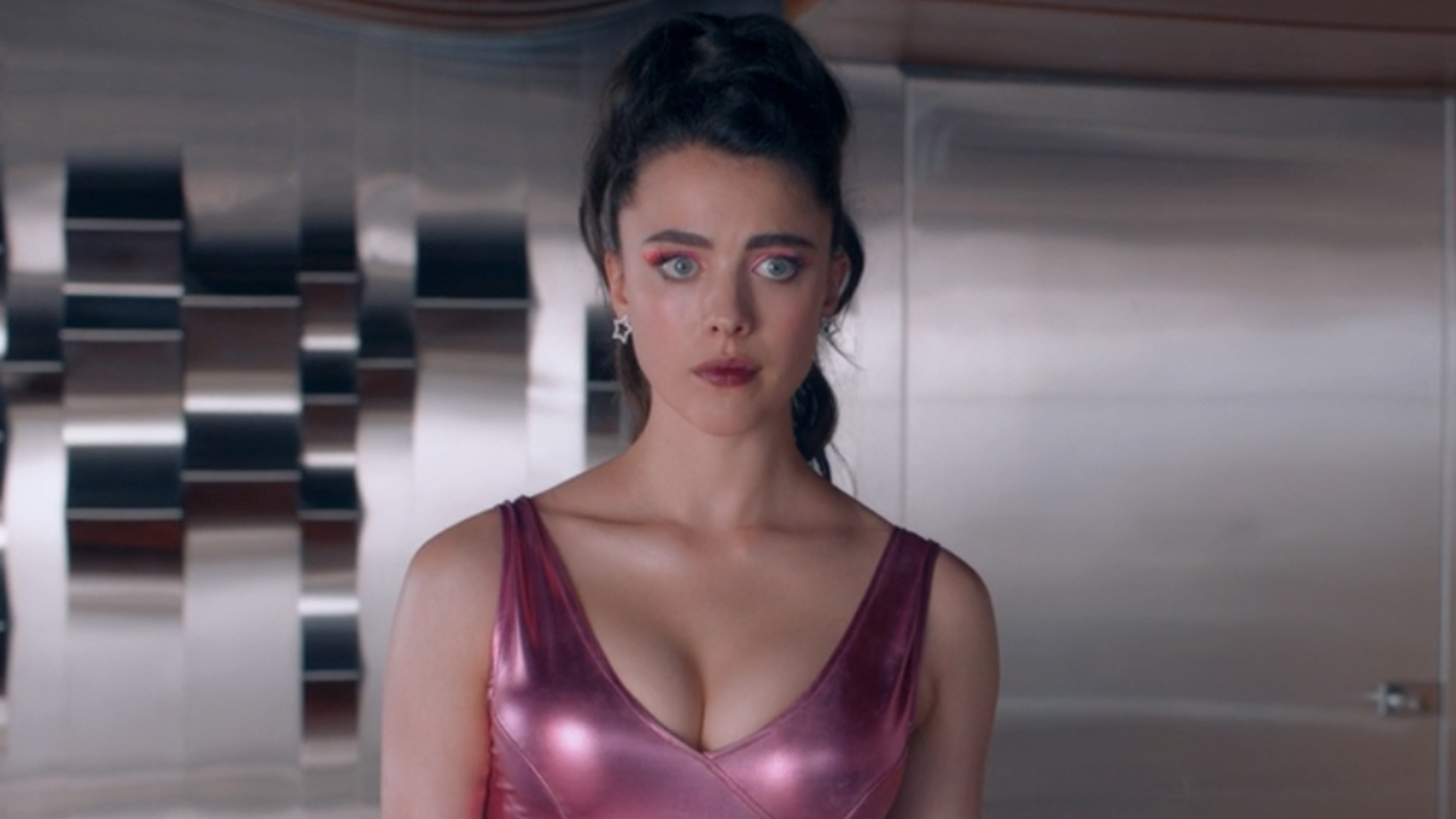 Margaret Qualley in a pink shiny top in The Substance