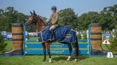 Michael Jackson and Oscar stand proudly wearing their Dubarry Burghley Young Event Horse winners rug in front of the Dubarry jump after winning the five-year-old final.