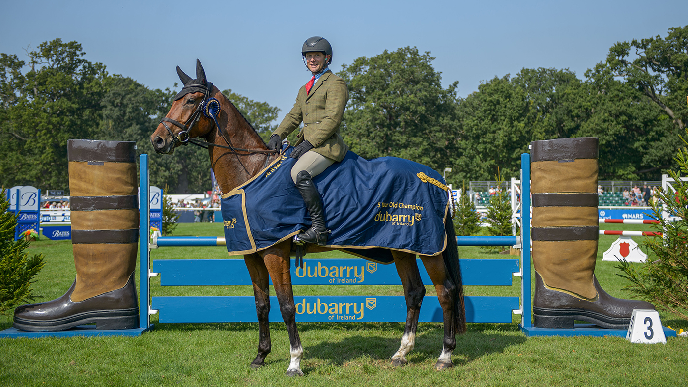 Michael Jackson and Oscar stand proudly wearing their Dubarry Burghley Young Event Horse winners rug in front of the Dubarry jump after winning the five-year-old final.