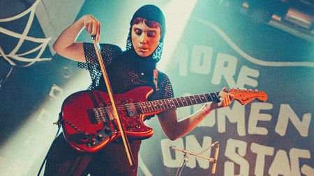 Janelle Borg bowing her guitar on stage