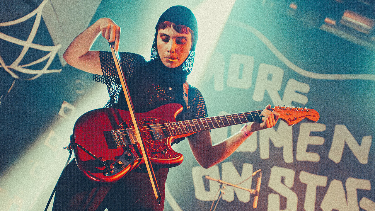 Janelle Borg bowing her guitar on stage