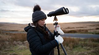 woman using binoculars on a tripod