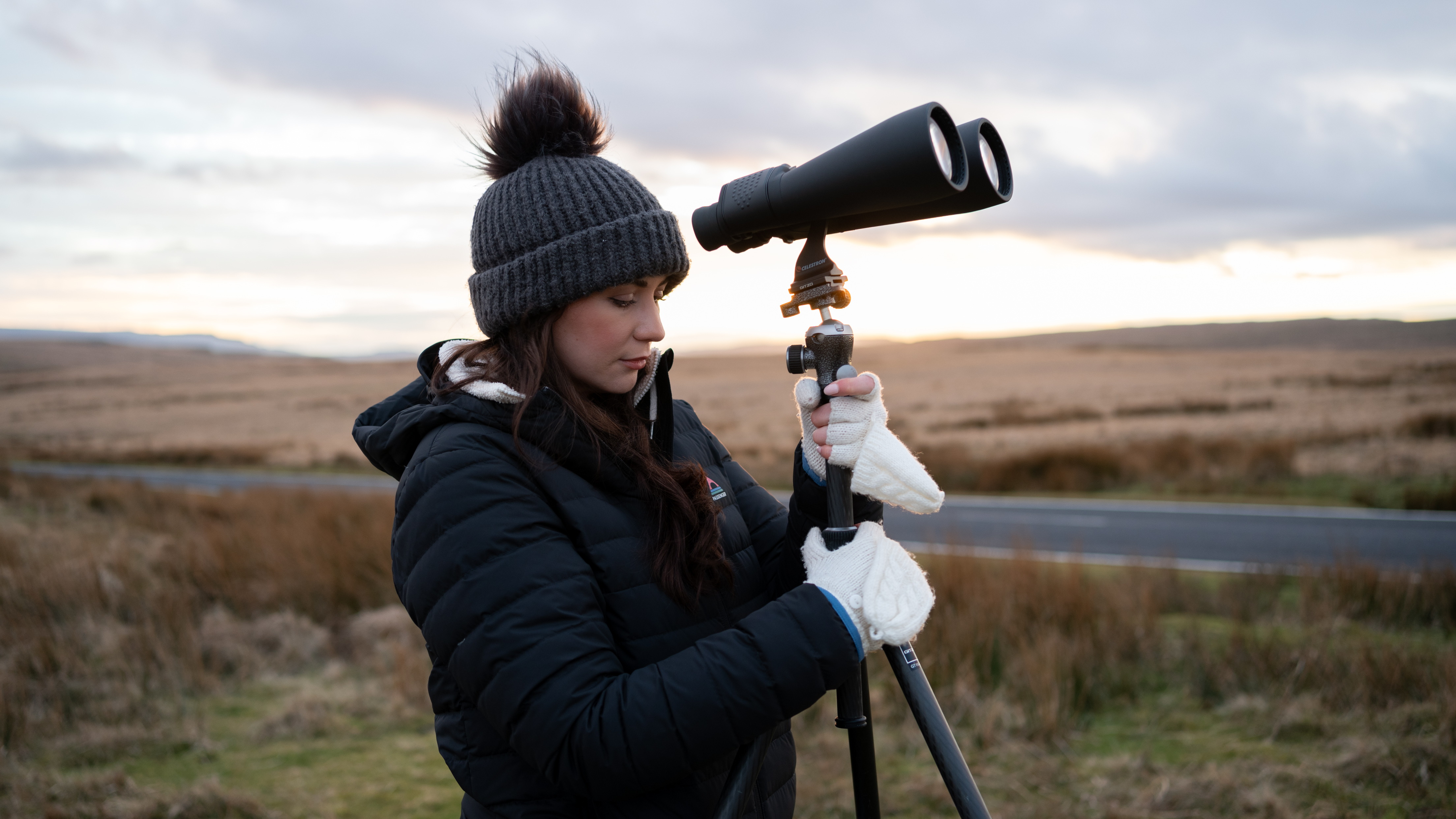 wanita menggunakan teropong pada tripod