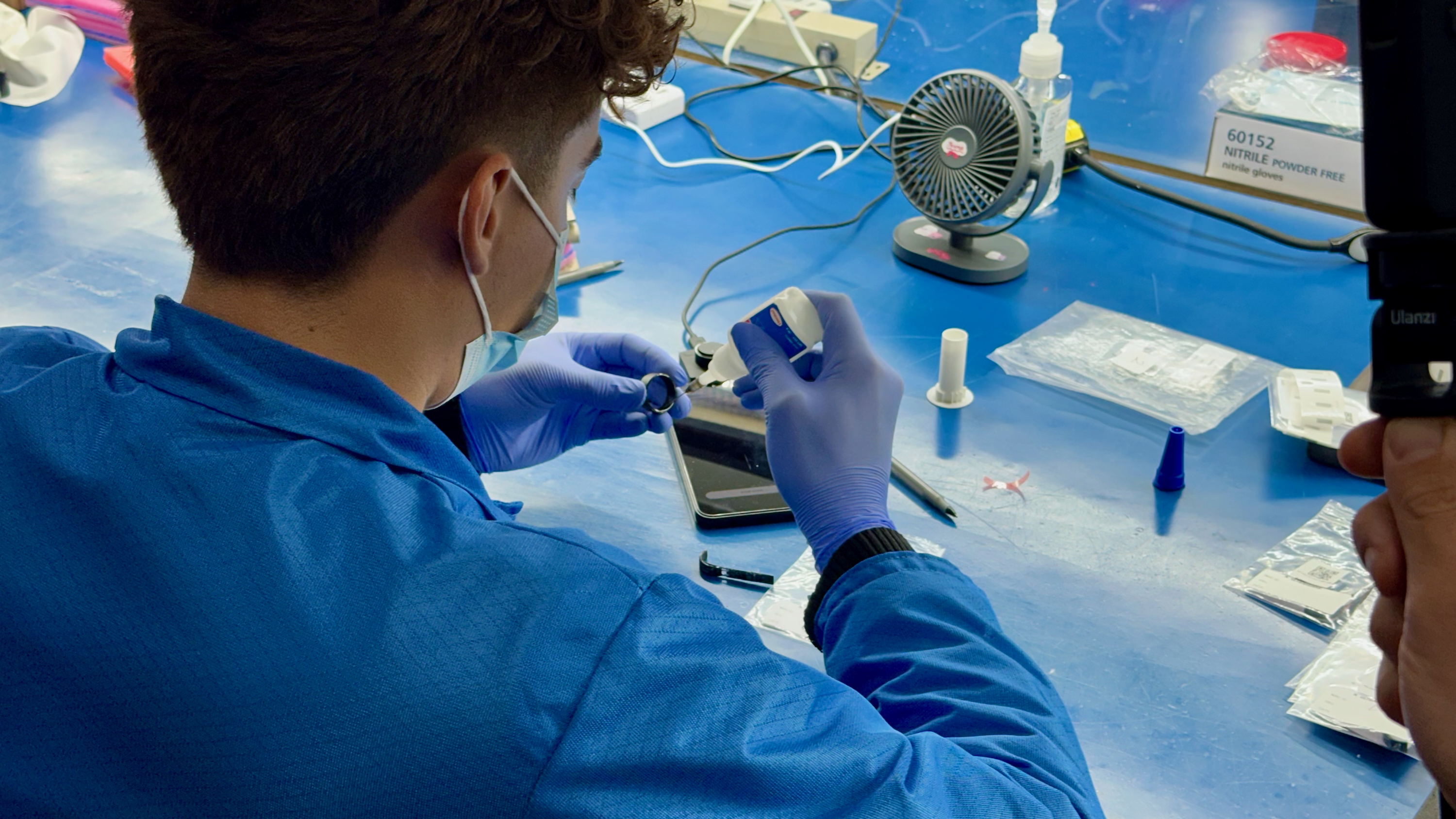An Ultrahuman factory worker placing glue onto a Ring Air component.