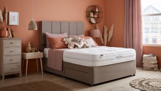 How to optimize your bedroom for sleep, according to an expert: An image showing a comfy bedroom decorated in warm colors of wood and orange