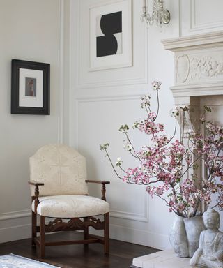 living room corner with cream chair and fireplace with artwork