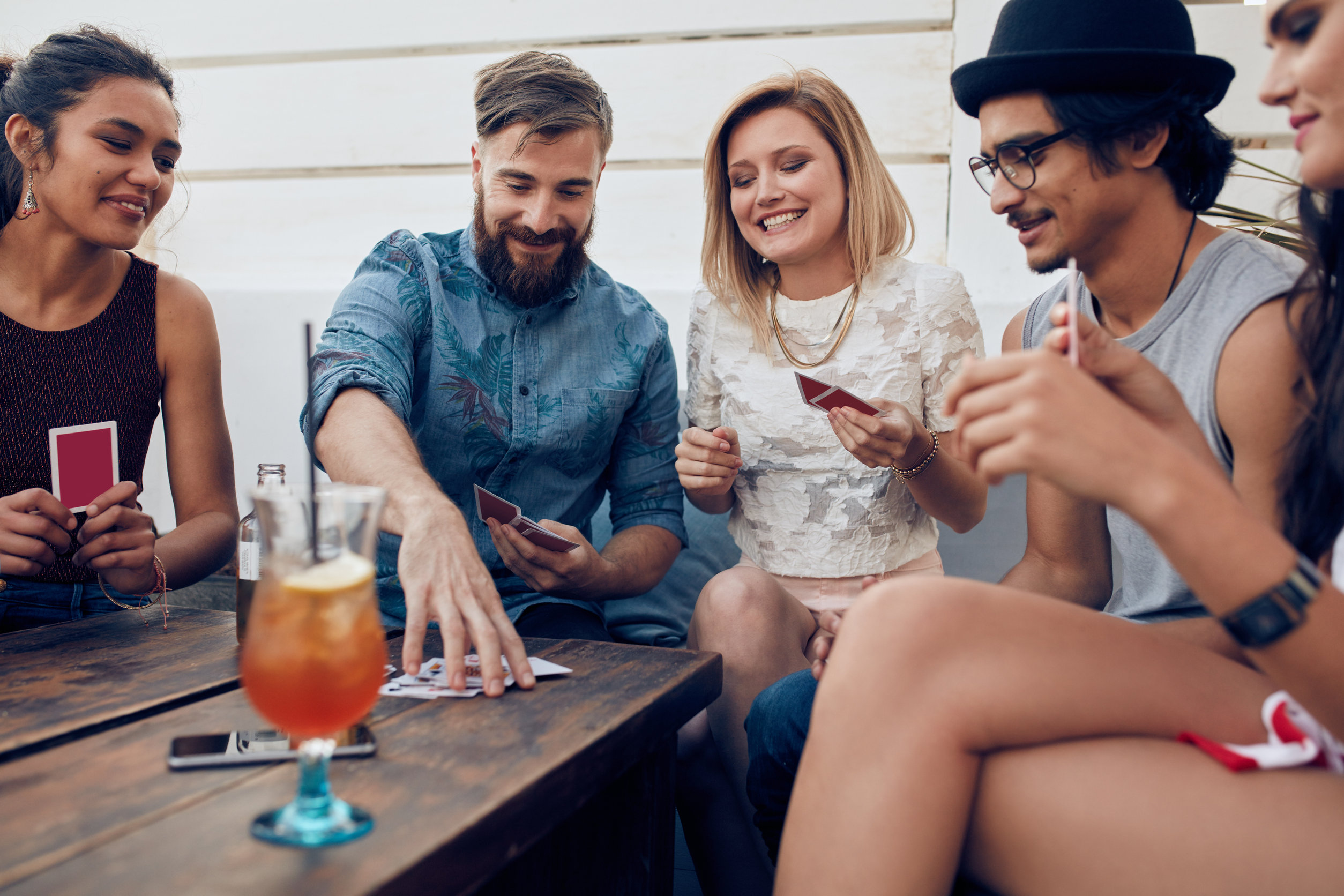 Persone che giocano intorno a un tavolino con drink
