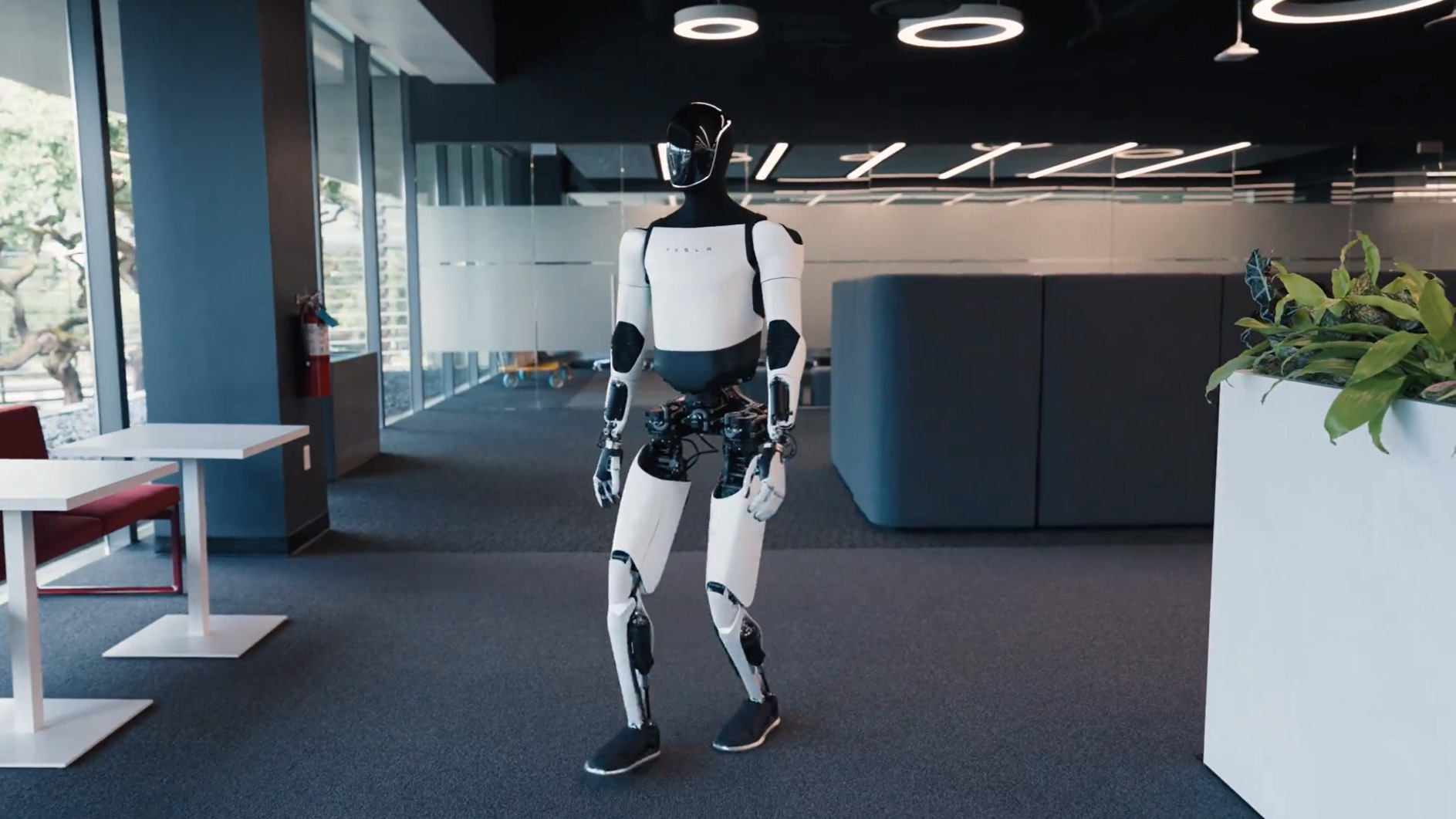 A Tesla promotional video showing the Optimus robot walking around an office