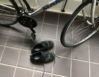 Photograph of bike with bike shoes next to it