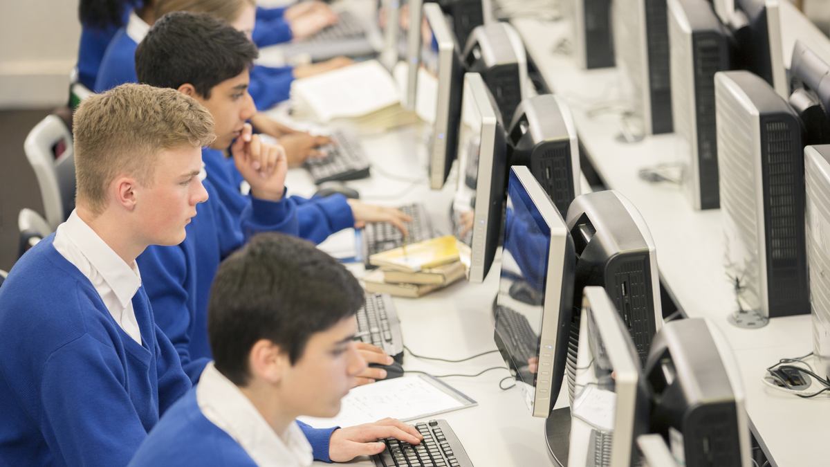 Teenage students using computers in computer room