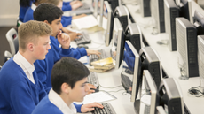 Teenage students using computers in computer room