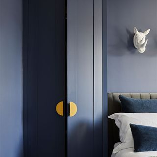dark blue bedroom with dark blue cupboard and pillows