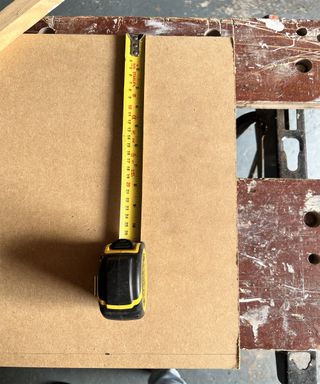 tape measure on piece of mdf upon a workbench