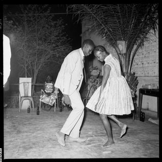 'Nuit de Noël (Happy Club)' by Malick Sidibé, 1963 - a black and white photo of a man and woman dancing barefoot