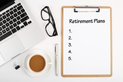 clipboard that says "retirement plans" and a checklist with a computer, glasses, and other desk items