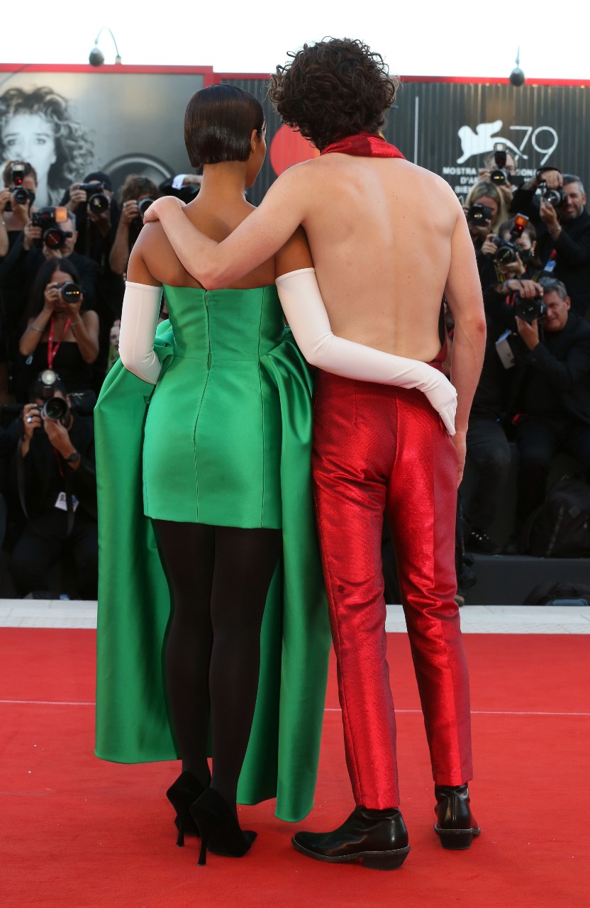 Espaldas de Taylor Russell, a la izquierda, con un vestido verde de Balenciaga y de Timothee Chalamet, a la derecha, con un conjunto rojo sin espalda de Haider Ackermann.