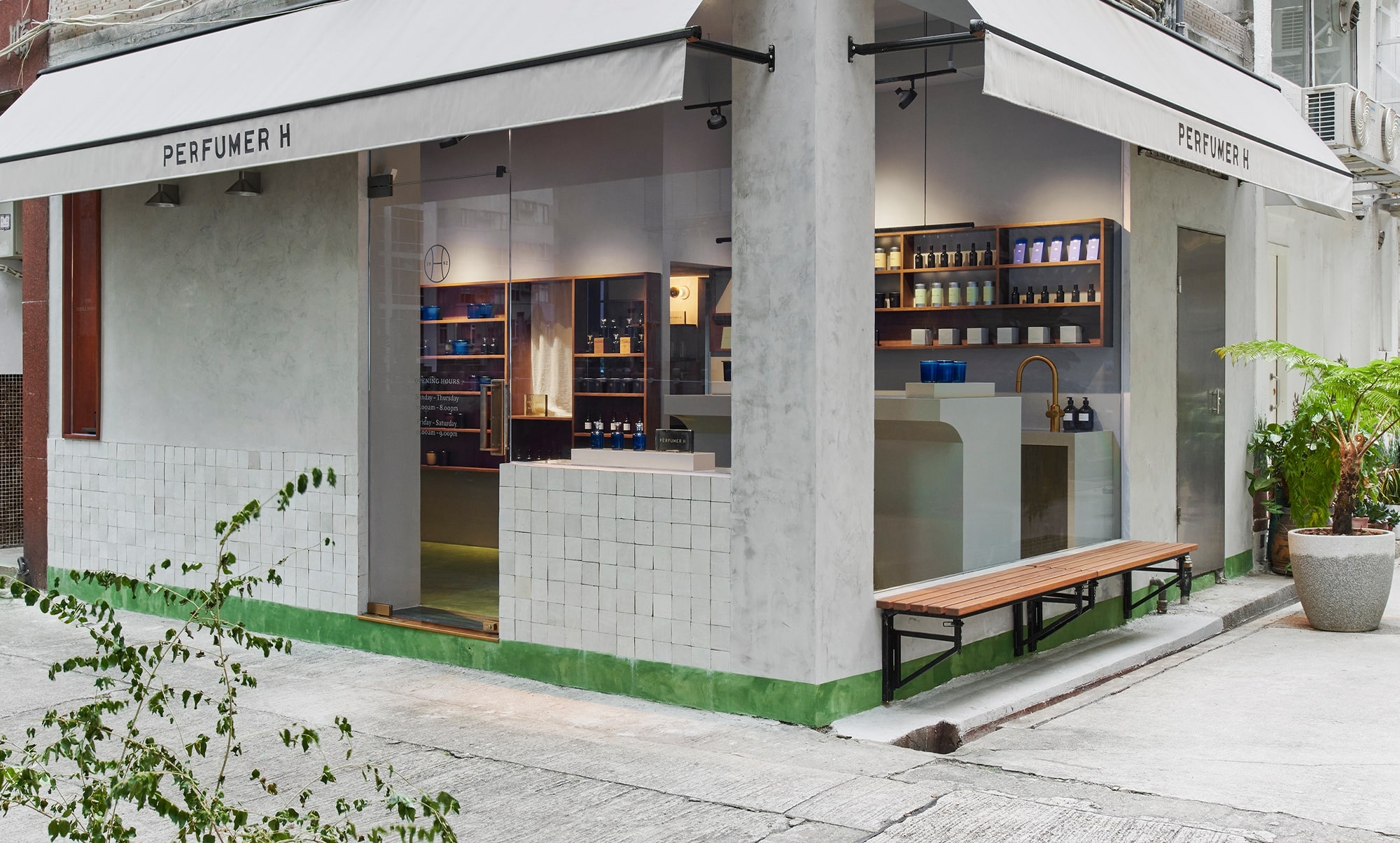 grey tiled shop front with awning and wooden bench