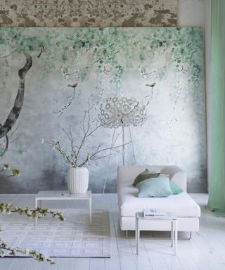 minimalist living room with white chaise, white side tables, botanical mural, pale green curtains, white floor