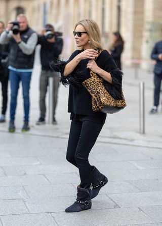 Kate Moss in black outfit and leopard print bag