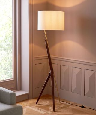 A tripod floor lamp in a traditional living room