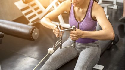 Woman using cable machine to lose weight at the gym