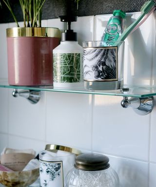 A bathroom with reused candle jars as toothbrush and toothpaste holder