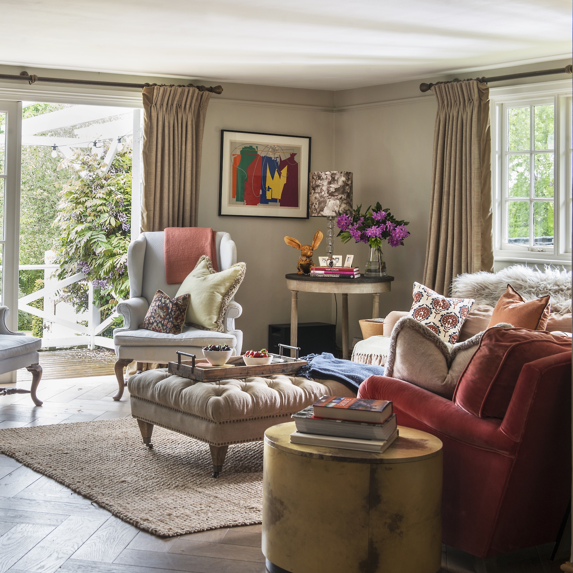 sittng room with sofas, upholstered ottoman and wing back chair