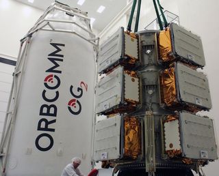 Eleven Orbcomm spacecraft are attached to their dispenser prior to being encapsulated within the Falcon 9’s payload fairing.