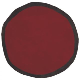 An irregular maroon rug