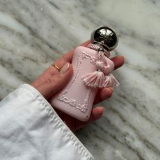 Hand holding bottle of Delina perfume