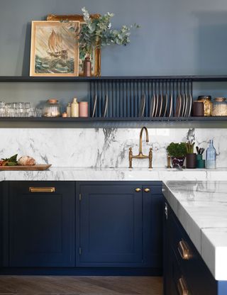 Blue kitchen with marble countertop and shelf