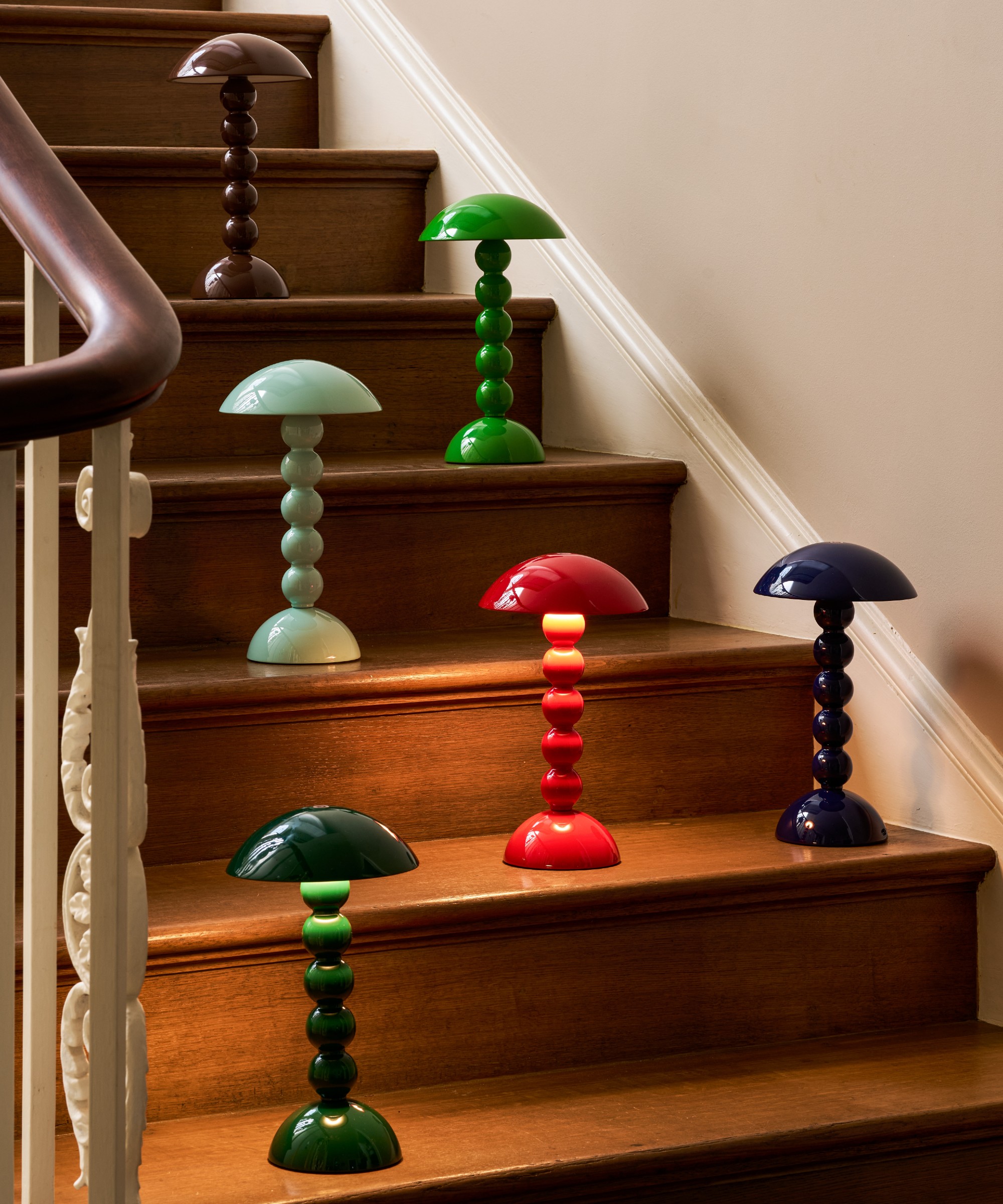 The six new Addison Ross bobbin lamp colourways displayed on a wooden staircase