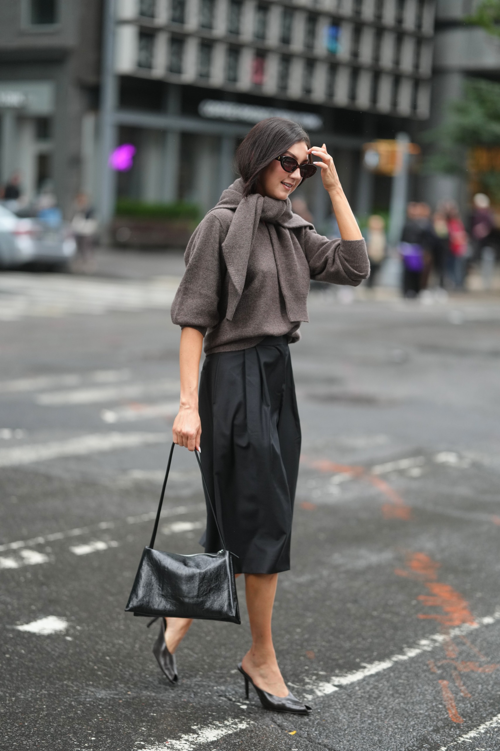 woman wearing double layered knits and long black pleated bermuda shorts