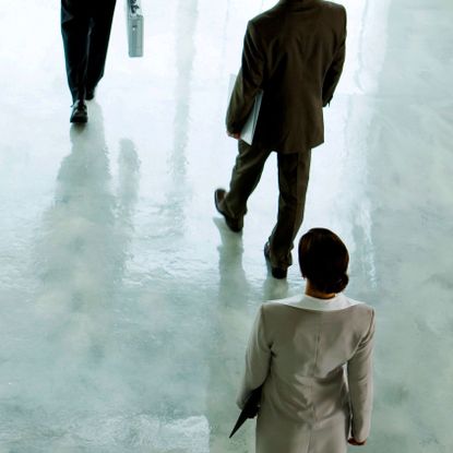 Executives shown from above walking across a hallway
